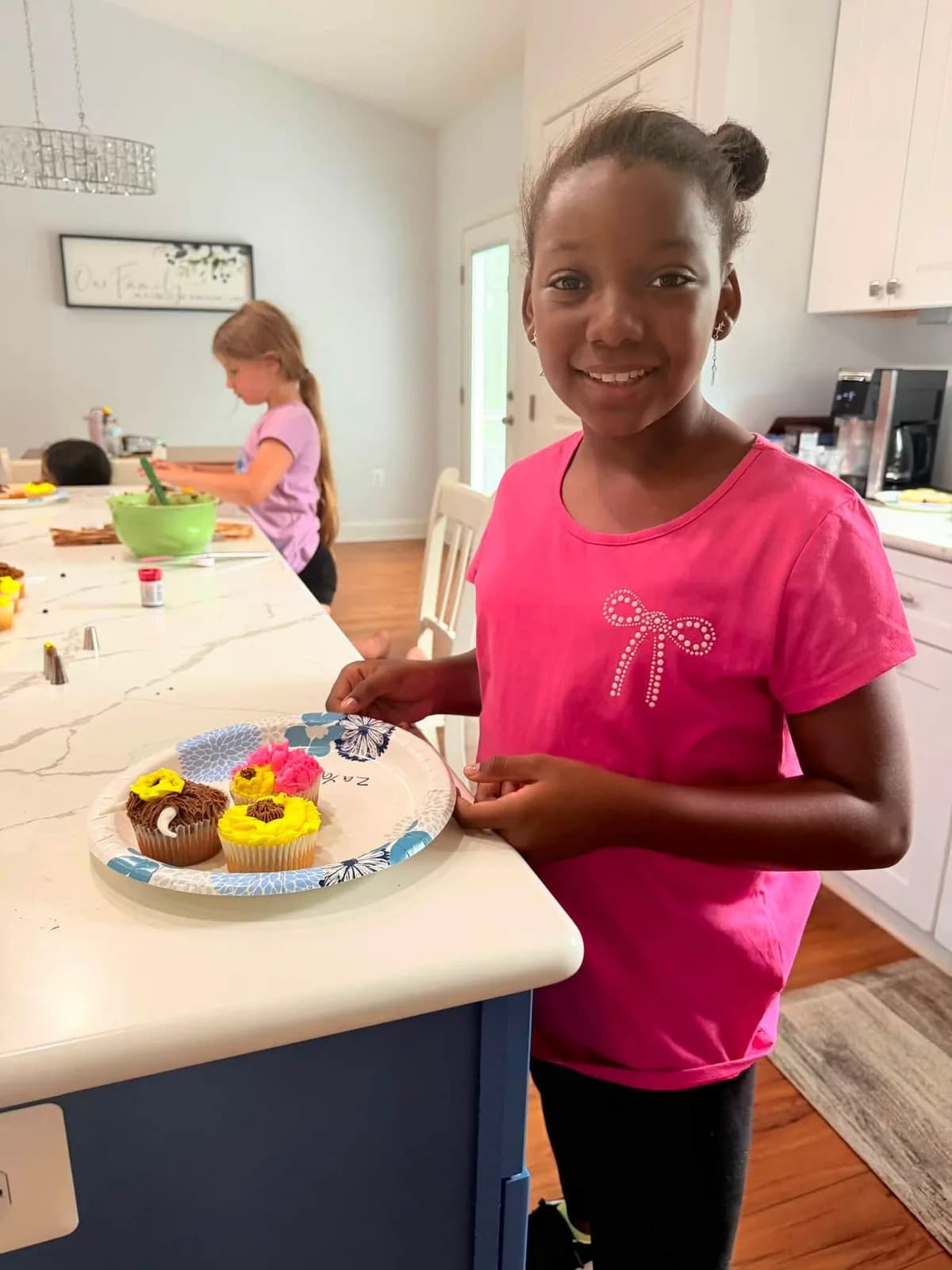 A class participant holding sunflower cupcakes